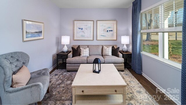 living area with plenty of natural light, dark wood-style floors, and baseboards