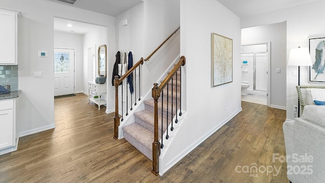 stairway featuring wood finished floors and baseboards