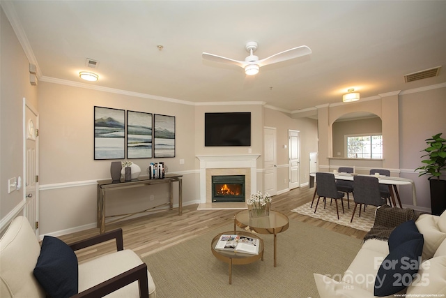 4938 Sunset Ridge Ct, Charlotte, NC 28269 - living room with wood finished floors, arched walkways, a ceiling fan, crown molding, and a high end fireplace