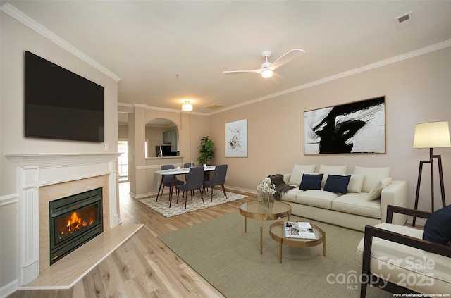 4938 Sunset Ridge Ct, Charlotte, NC 28269 - living room featuring light wood-type flooring, arched walkways, a glass covered fireplace, ornamental molding, and baseboards