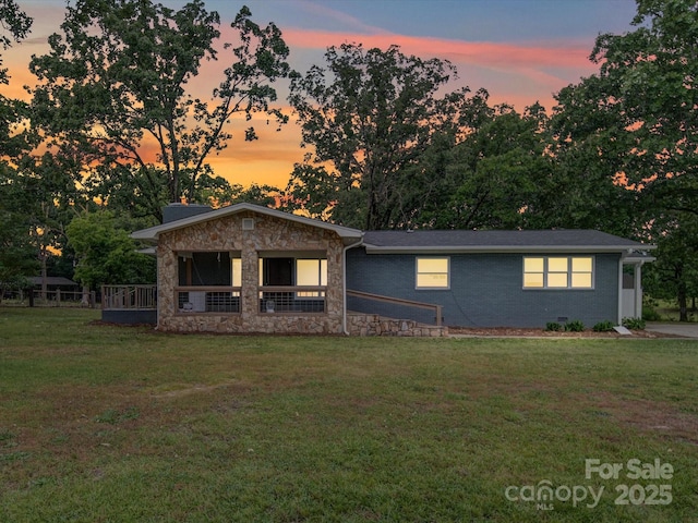 view of front of home with stone siding and a front lawn