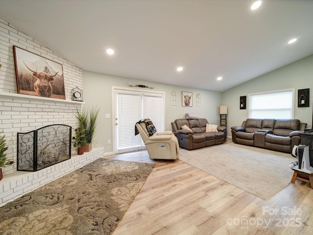 living room with vaulted ceiling, wood finished floors, a fireplace, and recessed lighting