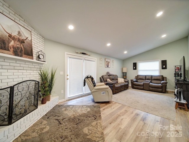 living area featuring lofted ceiling, wood finished floors, recessed lighting, a fireplace, and baseboards
