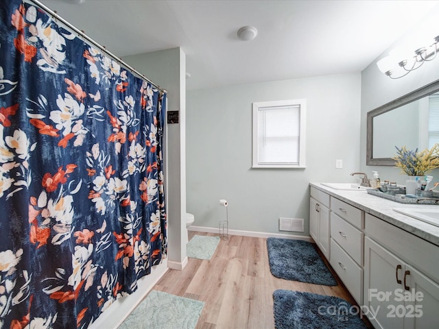 full bathroom with wood finished floors, double vanity, toilet, baseboards, and a shower with curtain