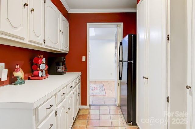 6664 Lake Shore Dr, Hickory, NC 28601 - kitchen featuring freestanding refrigerator, white cabinets, light countertops, ornamental molding, and light tile patterned flooring