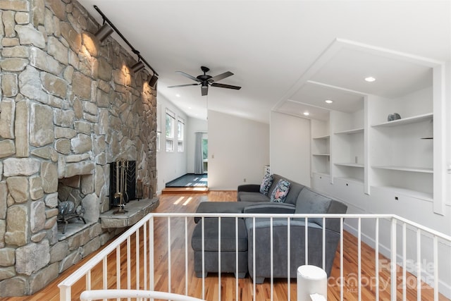 6664 Lake Shore Dr, Hickory, NC 28601 - unfurnished living room with wood finished floors, ceiling fan, a stone fireplace, baseboards, and built in features