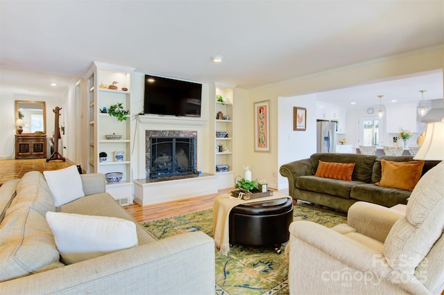 6664 Lake Shore Dr, Hickory, NC 28601 - living room featuring recessed lighting, a premium fireplace, ornamental molding, built in shelves, and wood finished floors