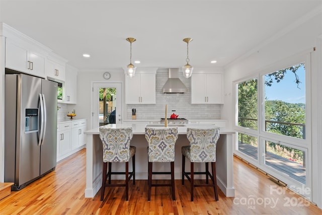 6664 Lake Shore Dr, Hickory, NC 28601 - kitchen with stainless steel refrigerator with ice dispenser, wall chimney range hood, light countertops, tasteful backsplash, and light wood-style flooring