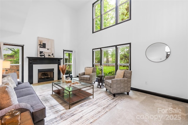 4339 Shannamara Dr, Matthews, NC 28104 - living area featuring a fireplace with flush hearth, a towering ceiling, and baseboards
