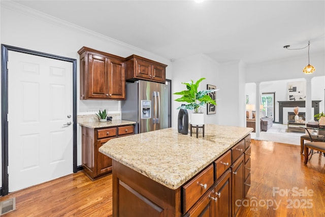 4339 Shannamara Dr, Matthews, NC 28104 - kitchen with stainless steel refrigerator with ice dispenser, decorative columns, light wood-style floors, a center island, and light stone countertops