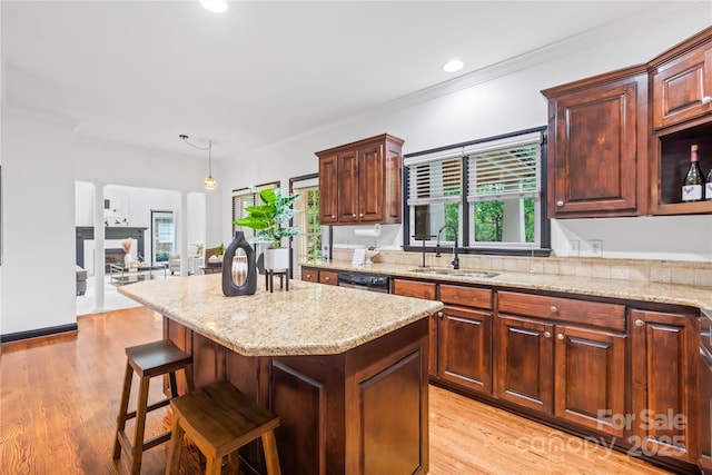 4339 Shannamara Dr, Matthews, NC 28104 - kitchen featuring a sink, dishwasher, light stone counters, light wood-style floors, and a kitchen island