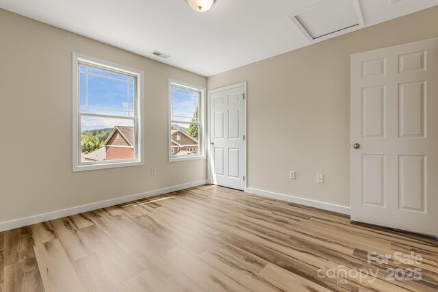 10 Coral Berry Dr, Candler, NC 28715 - unfurnished bedroom with attic access, light wood-style floors, and baseboards