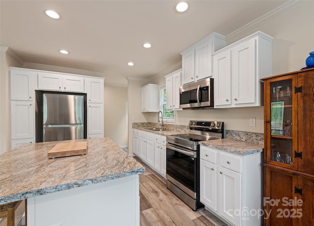 328 Mountain Lion Trl, Maggie Valley, NC 28751 - kitchen with appliances with stainless steel finishes, crown molding, a sink, a kitchen island, and white cabinets