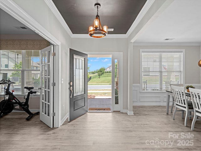 5013 Hamilton Mill Dr, Waxhaw, NC 28173 - foyer entrance featuring a chandelier, wood finished floors, ornamental molding, and a wainscoted wall