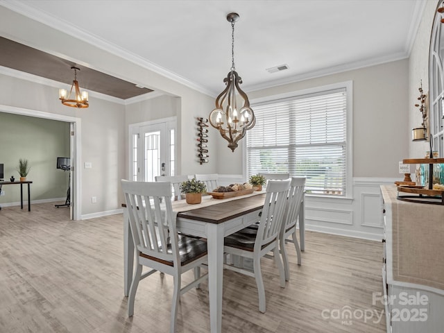 5013 Hamilton Mill Dr, Waxhaw, NC 28173 - dining room featuring a chandelier, light wood finished floors, crown molding, and wainscoting