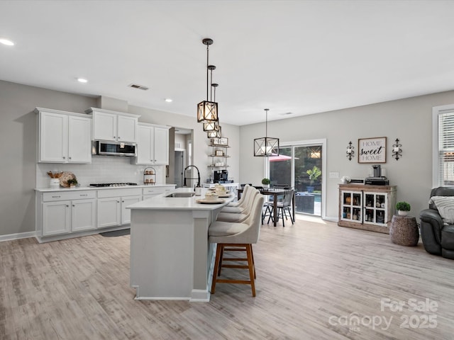 5013 Hamilton Mill Dr, Waxhaw, NC 28173 - kitchen with stainless steel microwave, gas cooktop, light wood-type flooring, healthy amount of natural light, and recessed lighting