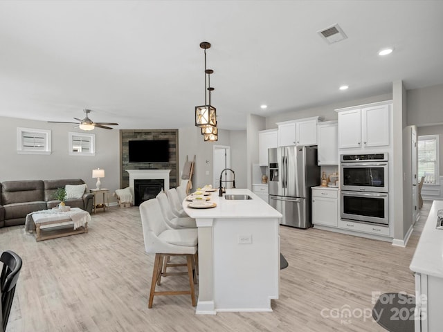 5013 Hamilton Mill Dr, Waxhaw, NC 28173 - kitchen with appliances with stainless steel finishes, light countertops, white cabinets, light wood-type flooring, and recessed lighting