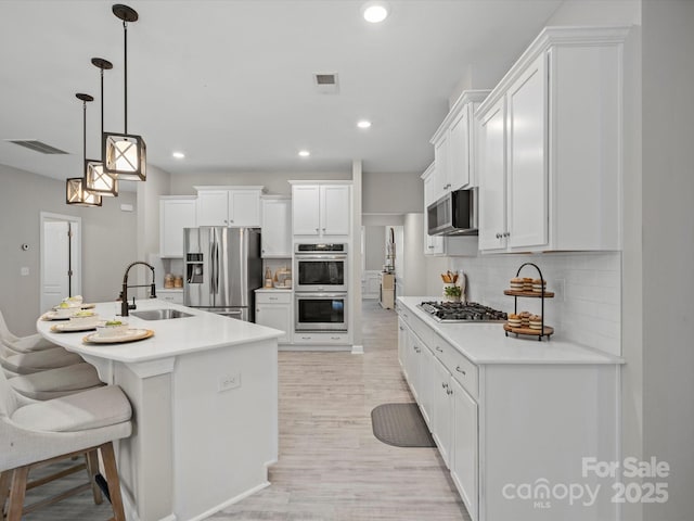 5013 Hamilton Mill Dr, Waxhaw, NC 28173 - kitchen featuring appliances with stainless steel finishes, decorative backsplash, white cabinetry, light countertops, and recessed lighting