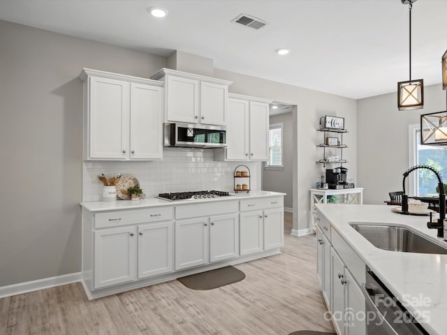 5013 Hamilton Mill Dr, Waxhaw, NC 28173 - kitchen featuring stainless steel appliances, white cabinets, tasteful backsplash, light wood finished floors, and recessed lighting