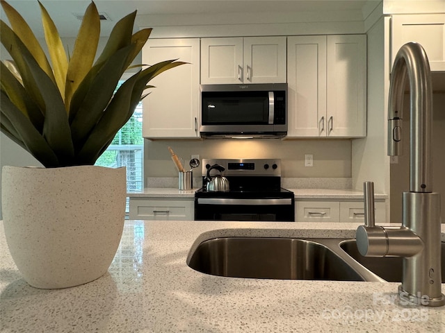 2012 Crown Point Dr Unit A, Albemarle, NC 28001 - kitchen featuring stainless steel microwave, electric range, white cabinetry, and light stone countertops