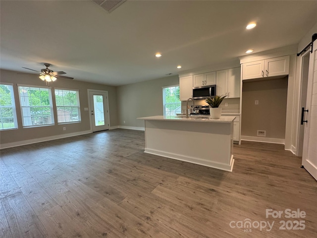 2012 Crown Point Dr Unit A, Albemarle, NC 28001 - kitchen featuring stainless steel microwave, a barn door, recessed lighting, white cabinets, and baseboards