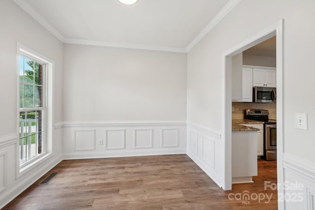 spare room with light wood-style flooring and crown molding