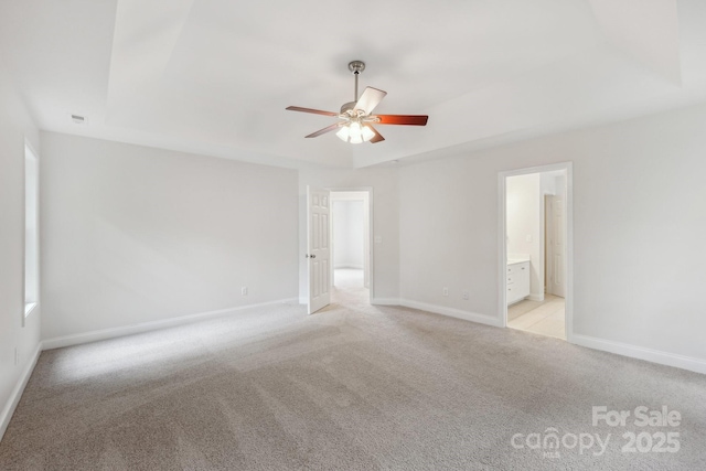 spare room featuring ceiling fan, light carpet, and baseboards