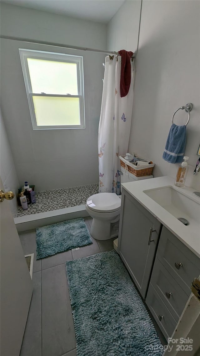 718 Dogwood Ave, Lincolnton, NC 28092 - bathroom featuring a shower stall, toilet, vanity, and tile patterned flooring