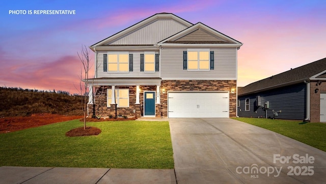 view of front of house featuring stone siding, concrete driveway, a garage, a lawn, and covered porch