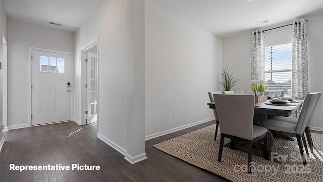 dining space with healthy amount of natural light, wood finished floors, and baseboards