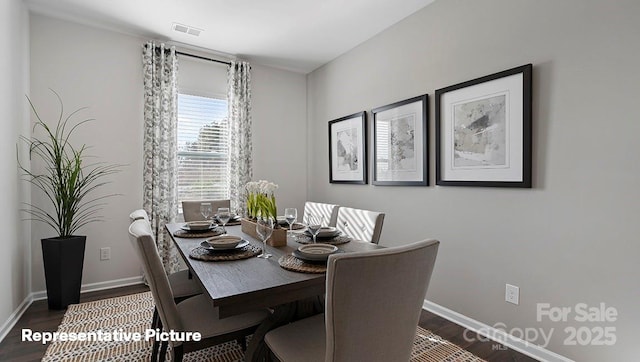 dining area featuring dark wood-style floors and baseboards