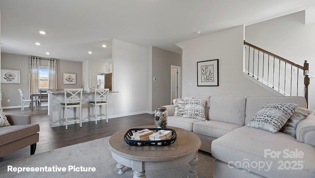 living area featuring recessed lighting, dark wood finished floors, baseboards, and stairs