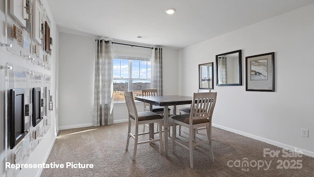 carpeted dining area featuring baseboards