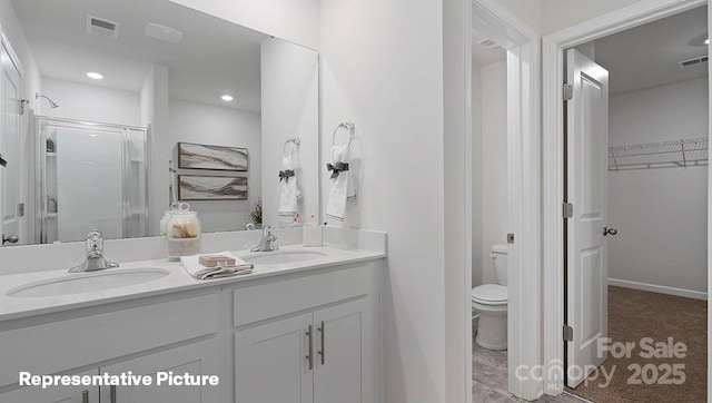 bathroom with toilet, a shower stall, double vanity, a spacious closet, and recessed lighting