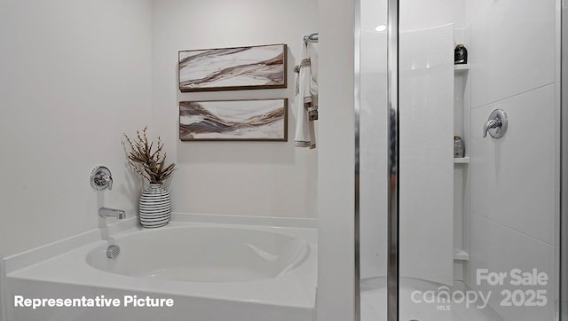 full bathroom featuring a shower stall and a garden tub