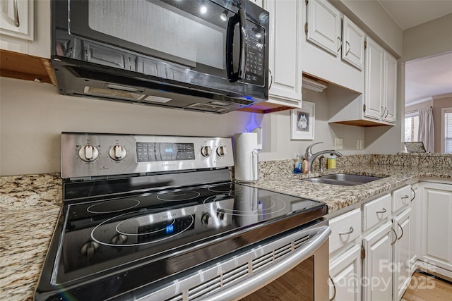 kitchen with electric stove, black microwave, a sink, white cabinets, and light stone counters