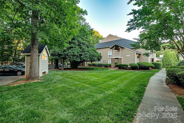view of front of home featuring roof with shingles and a front yard