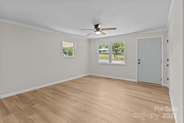 unfurnished room featuring ceiling fan, crown molding, light wood-style flooring, and baseboards