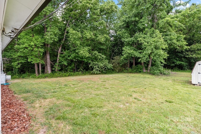 view of green lawn featuring a storage shed and an outdoor structure
