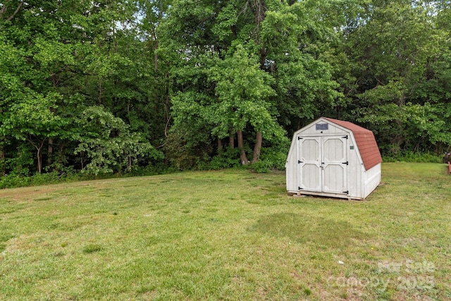 view of grassy yard featuring a storage shed and an outbuilding