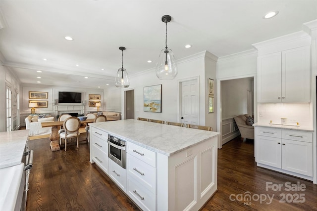 5806 Bentway Dr, Charlotte, NC 28226 - kitchen with open floor plan, a center island, white cabinetry, dark wood-style floors, and a fireplace