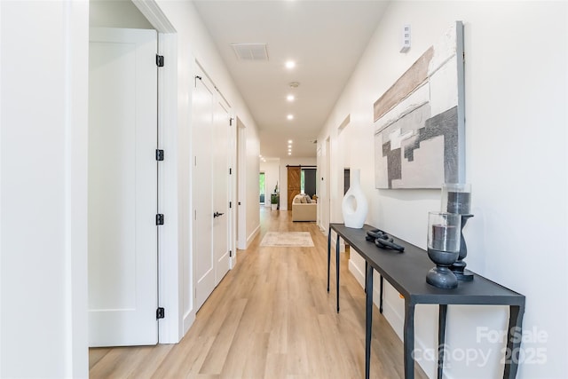 corridor with light wood-type flooring and recessed lighting