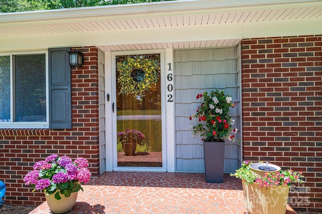 doorway to property featuring brick siding