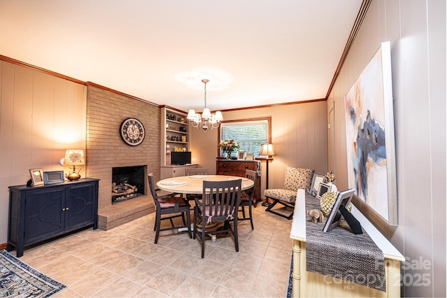dining space with crown molding, a chandelier, light tile patterned floors, and a fireplace