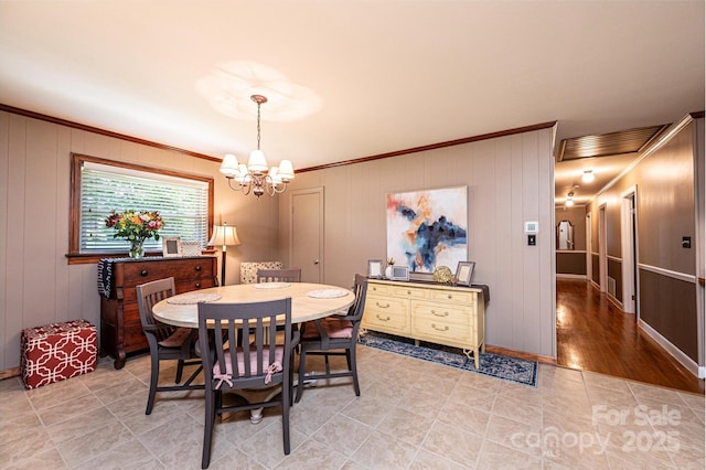 dining room with crown molding, a chandelier, light tile patterned flooring, and baseboards