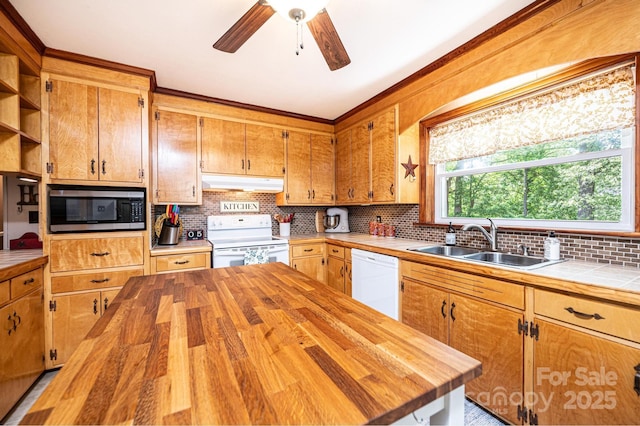 kitchen with white appliances, under cabinet range hood, a sink, butcher block counters, and ornamental molding