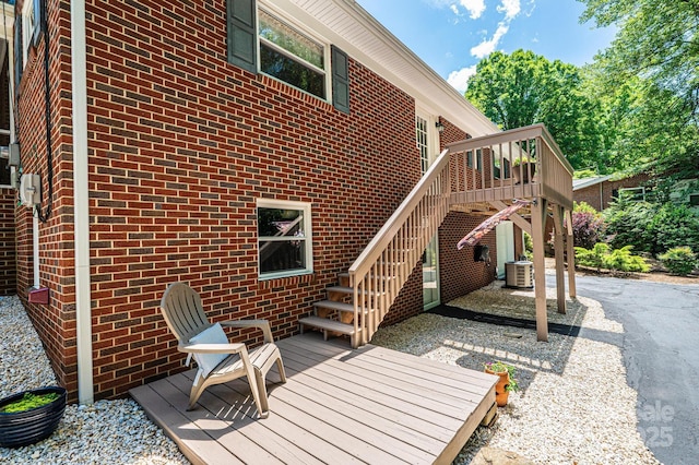 wooden terrace featuring cooling unit and stairs