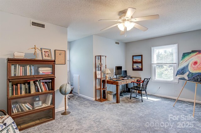 office space with a ceiling fan, carpet floors, a textured ceiling, and baseboards