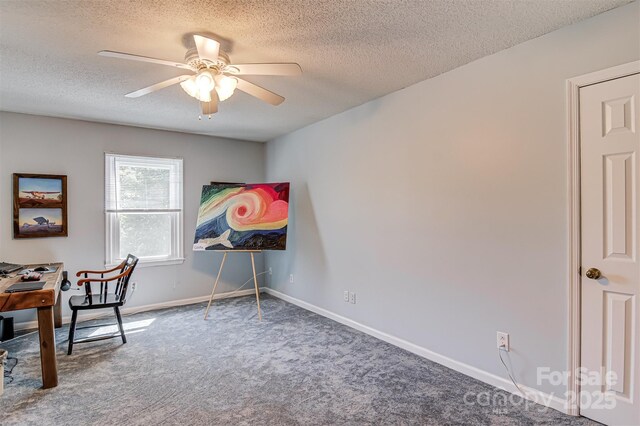 carpeted office space featuring a textured ceiling, ceiling fan, and baseboards