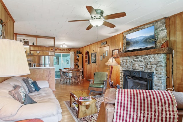 51 Atari Rd, Waynesville, NC 28786 - living room featuring wood finished floors, a ceiling fan, wood walls, and a stone fireplace